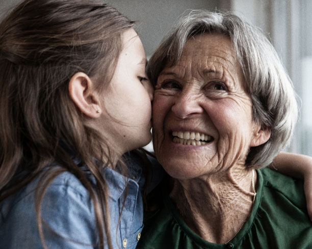 Young girl kissing her grandmother.